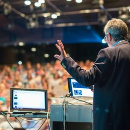 corporate communications speaker in front of crowd