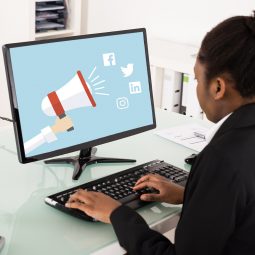 Woman working at computer with social media icons